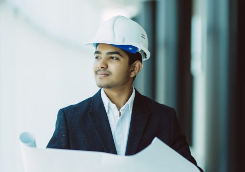 Indian Architect or engineer at work on a building site.